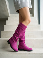 Damen Kniestiefel in Fuchsia, getragen auf einer Betontreppe