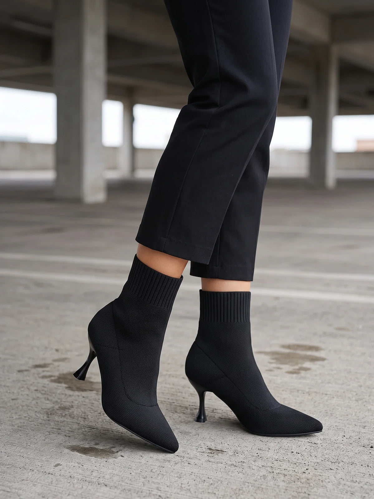 Damen Sock Boots in Schwarz, getragen an Betonsäulen