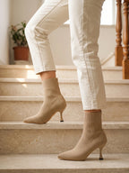 Damen Sock Boots in Beige, getragen auf einer Marmortreppe