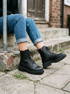 Damen Worker Boots in Schwarz, getragen auf einer Betontreppe